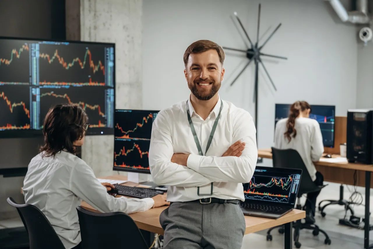 Investor vor Handelsbildschirmen als Symbolbild zum SIRV Investor Visum